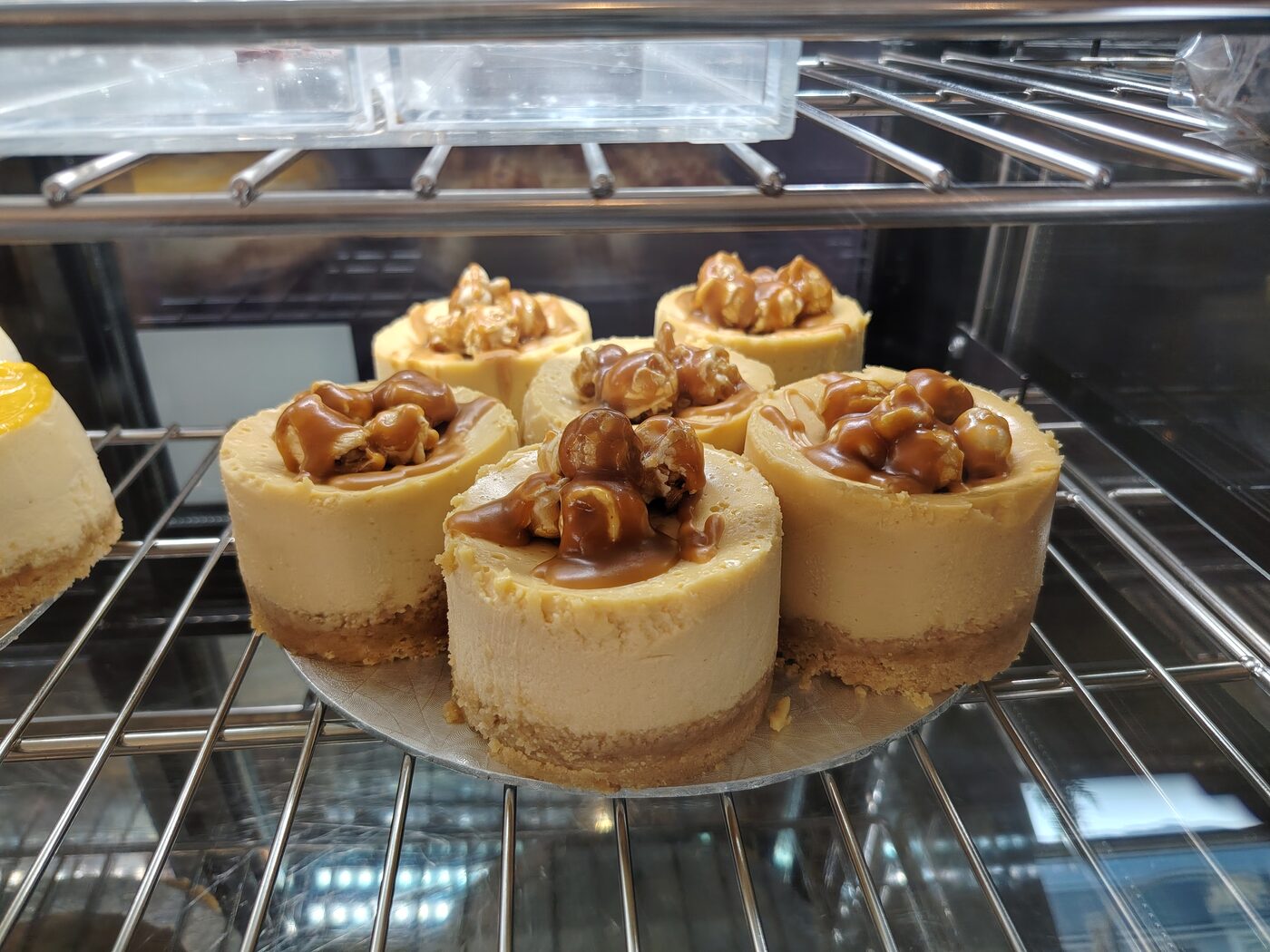 Caramel and nut topped cheesecakes on a cooling rack